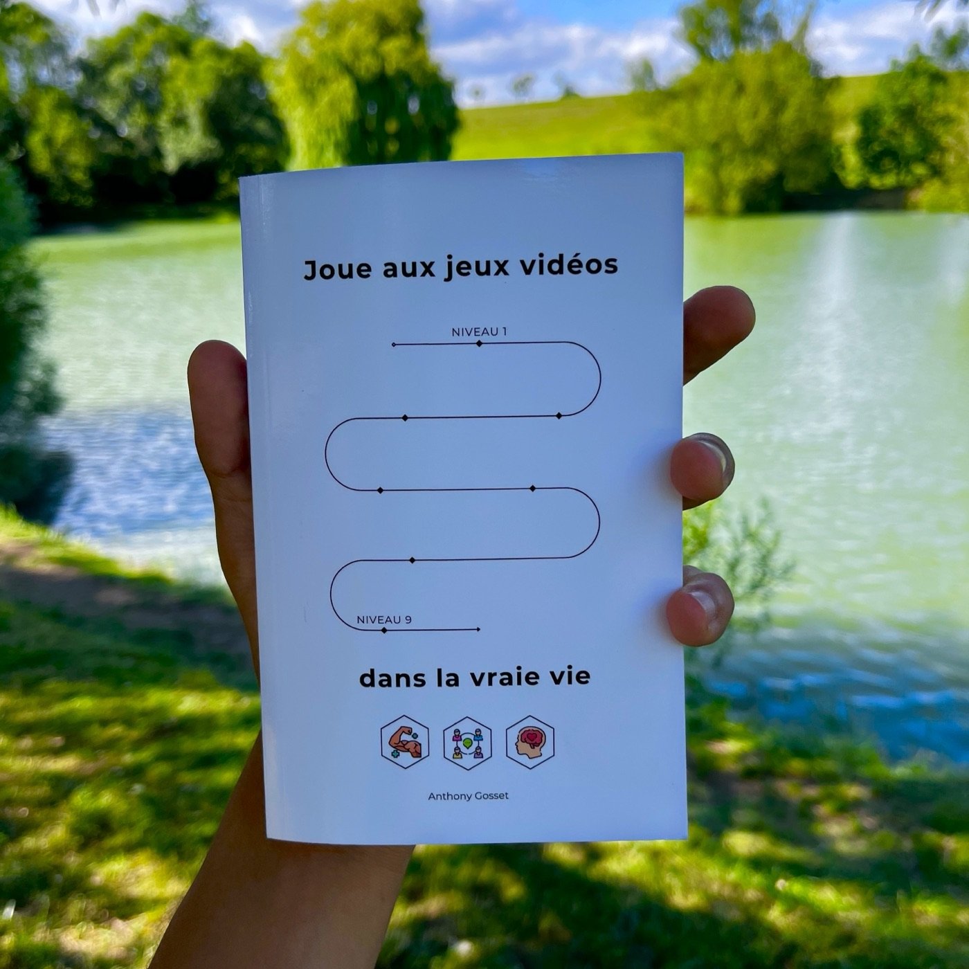 Le livre tenu en main devant un lac